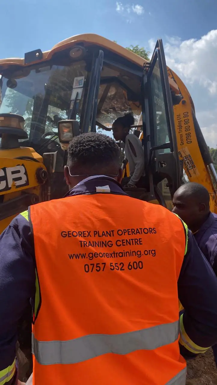 Instructor guiding students through safe entry into a backhoe loader cab