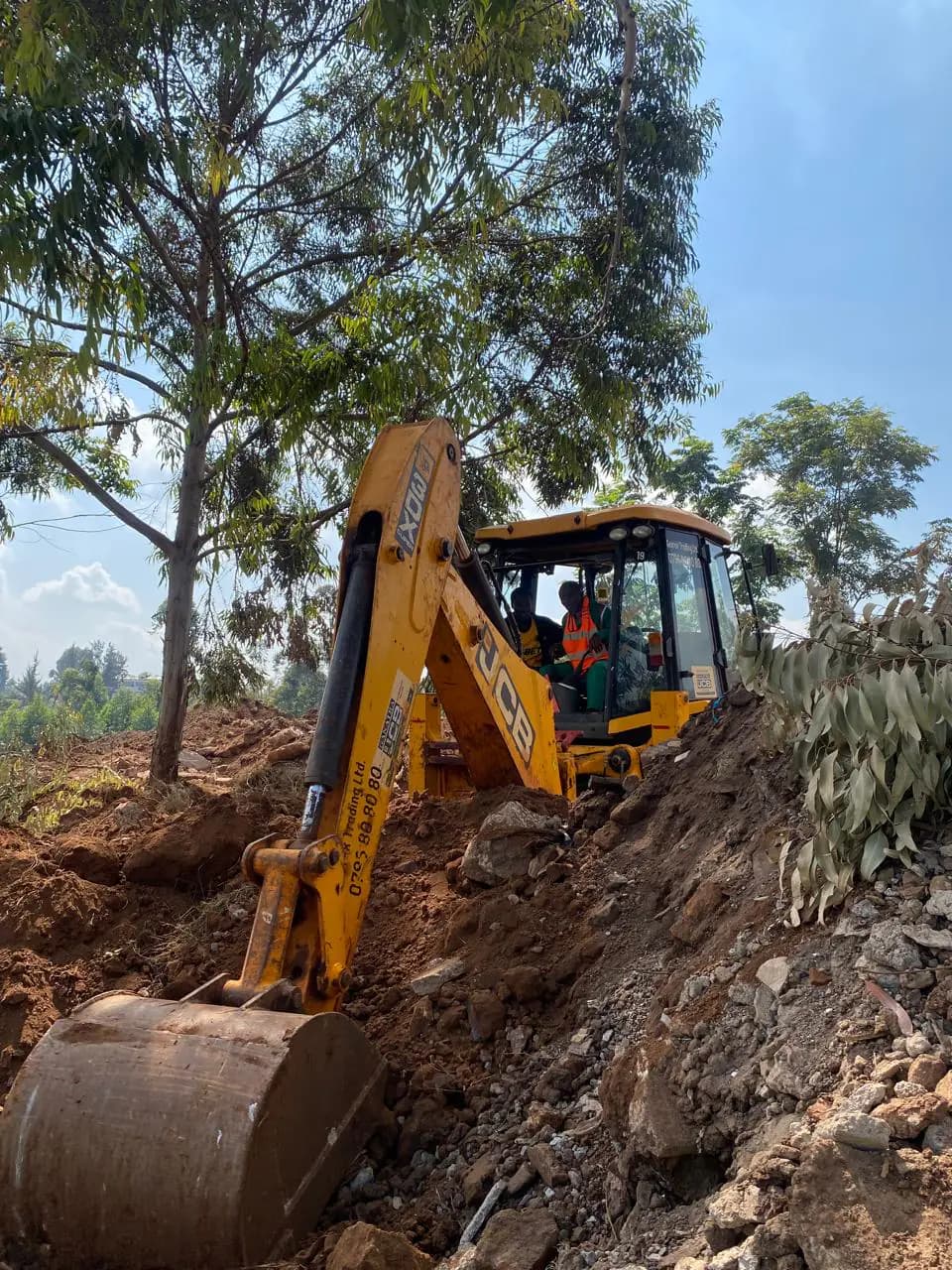 Backhoe bucket working through a marked excavation area during practical training