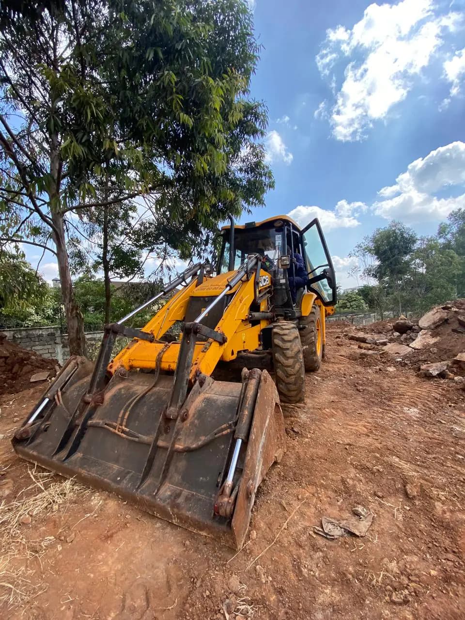 JCB front-loader bucket positioned for a student handling exercise